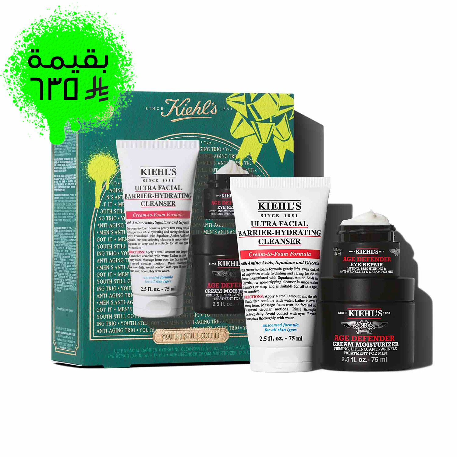 A graphic featuring a dark teal Kiehl’s gift box with white and gold accents on the left. The box contains three products. To the right of the box, the same three products are displayed outside of the box: a white tube of "KIEHL’S ULTRA FACIAL BARRIER-HYDRATING CLEANSER," a small black and red jar of "KIEHL’S AGE DEFENDER EYE REPAIR," and a larger black and red jar of "KIEHL’S AGE DEFENDER CREAM MOISTURIZER." The box is decorated with bright green graphic paint splatters and a bow design and features the text "YOUTH STILL GOT IT" at the bottom.