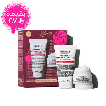 A graphic displays a Kiehl's gift set box, primarily in dark red, featuring a pink bow graphic in the upper right and a pink paint splatter in the lower left. The box states "DUO IT FOR THE HYDRATION" on its front, along with "ULTRA FACIAL BARRIER-HYDRATING CLENSER + ULTRA FACIAL CREAM. To the right of the box, the two products are shown outside their packaging.