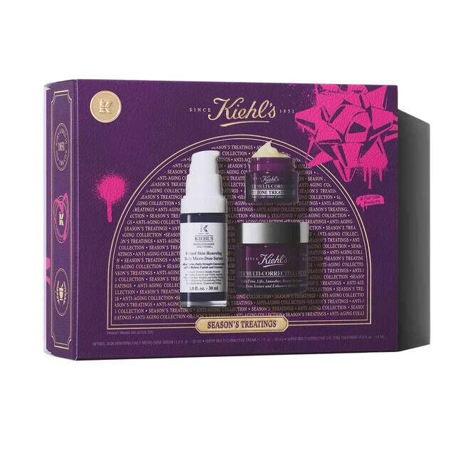 A graphic featuring a rectangular purple and pink Kiehl's "SEASON'S TREATINGS ANTI-AGING COLLECTION" gift set box, which contains a white and purple bottle of Retinol Skin-Renewing Daily Micro-Dose Serum, a small purple jar of Super Multi-Corrective Eye Zone Treatment, and a larger purple jar of Super Multi-Corrective Cream.