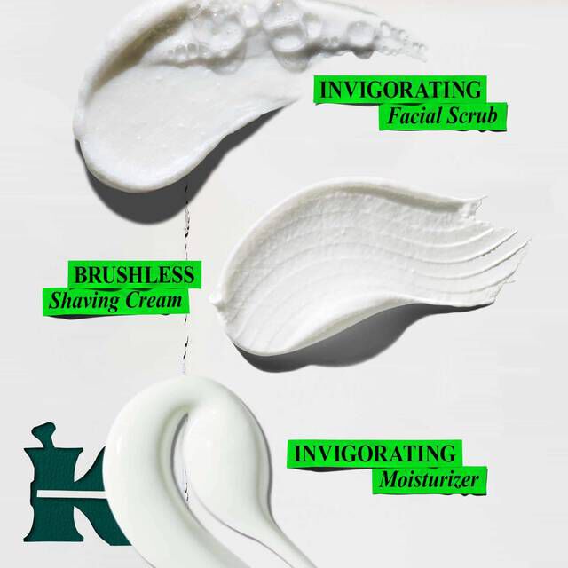 A graphic showing three white swirls of product against a white background. The top rough white swirl is labeled "INVIGORATING Facial Scrub." The middle smooth white swirl is labeled "BRUSHLESS Shaving Cream." The bottom light green swirl is labeled "INVIGORATING Moisturizer." A dark green "K" logo is in the lower left corner.